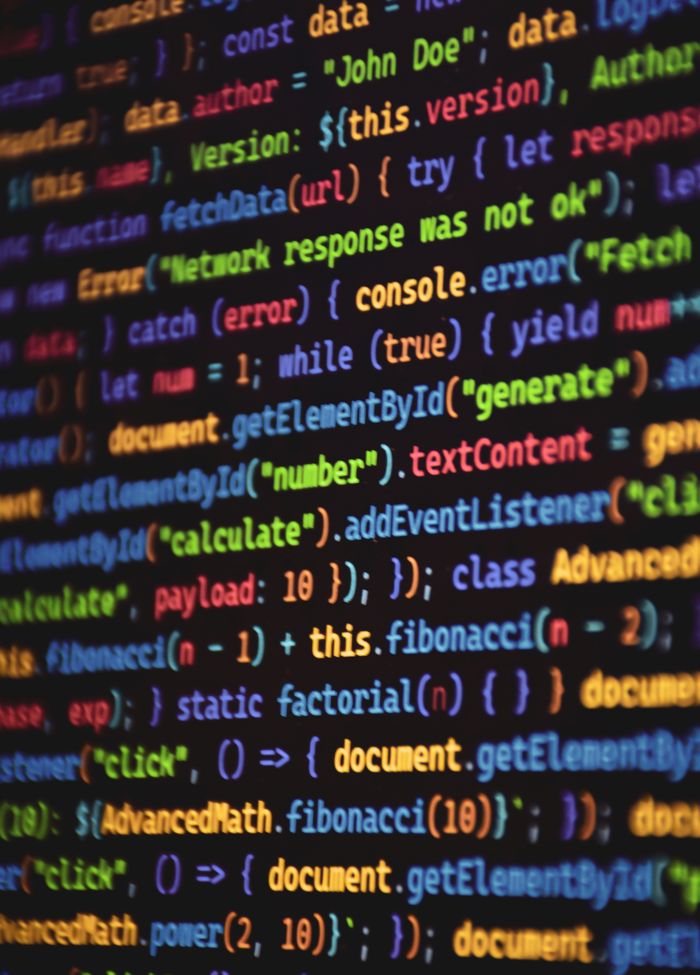 creative-approach-img Close-up of vibrant colored JavaScript code showing functions and syntax on a dark screen.