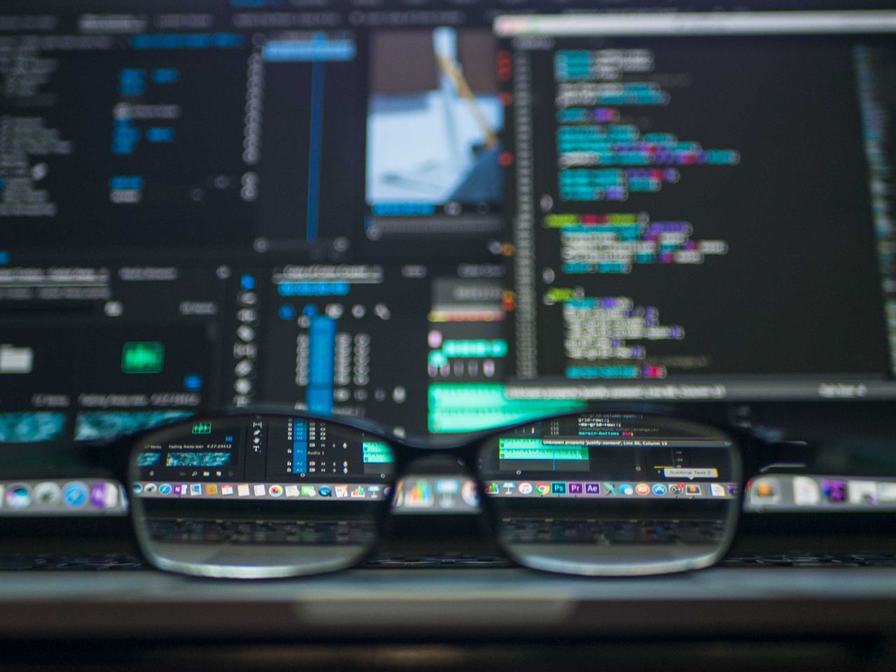 portfolio-04 Eyeglasses reflecting computer code on a monitor, ideal for technology and programming themes.